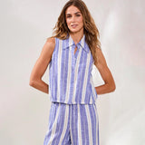 Woman wearing a blue and white striped sleeveless top and pants on a light gray background