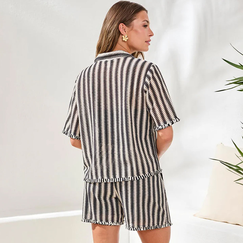 Woman wearing a black and white striped outfit with a blurred background