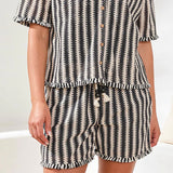 Person wearing a black and white patterned pajama set on a light background
