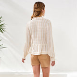 Woman wearing a striped shirt and beige shorts against a white background