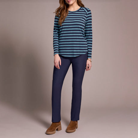 Person wearing a striped sweater and blue pants on a plain background