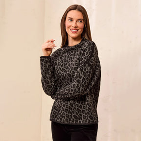 A woman modeling a black and gray leopard print long-sleeve top against a neutral beige background.