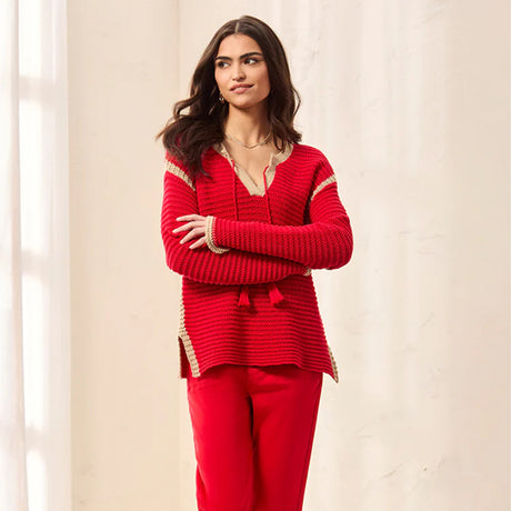 Woman wearing a red outfit with gold trim against a beige background
