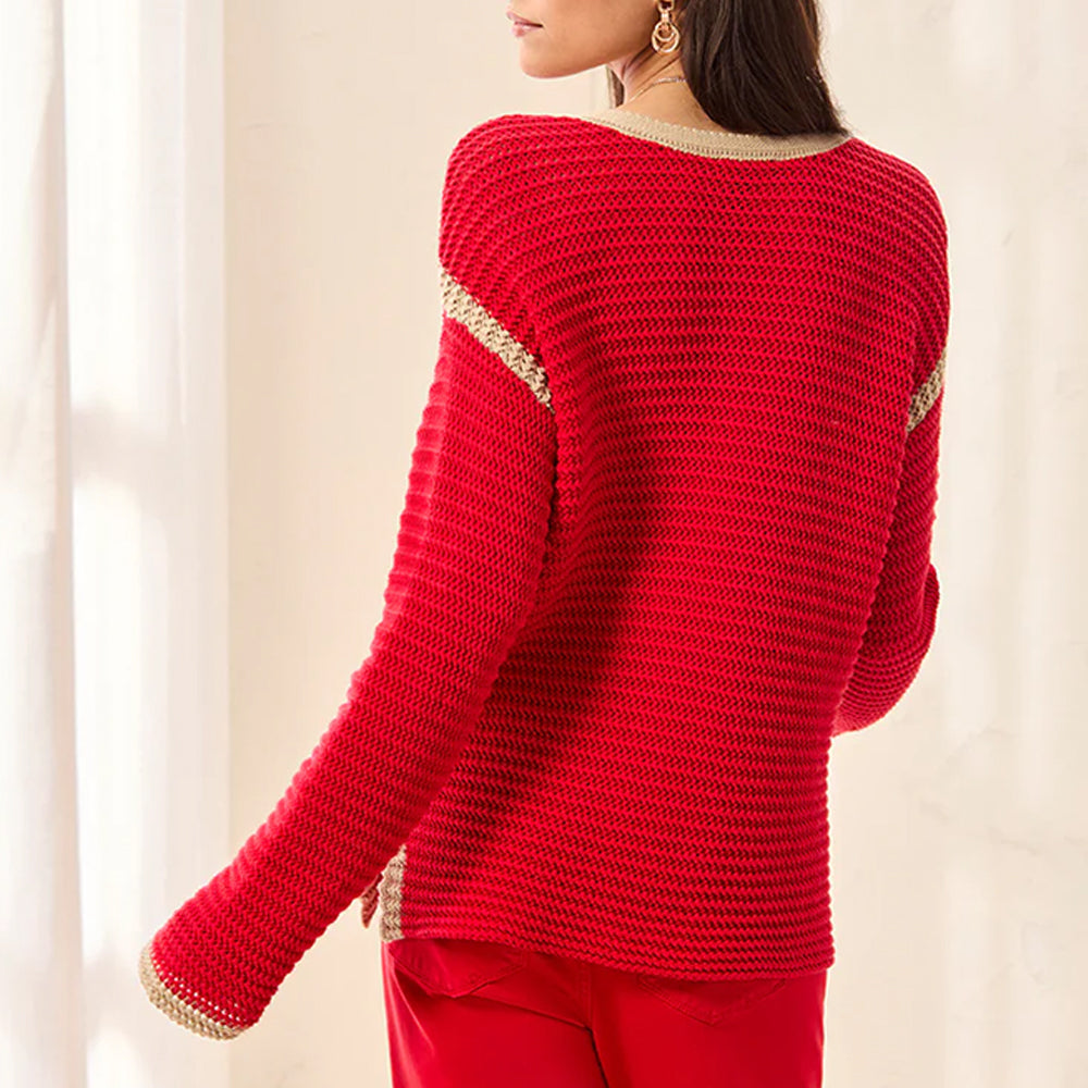 Red sweater with gold trim on a neutral background