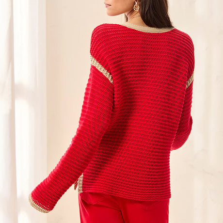 Red sweater with gold trim on a neutral background
