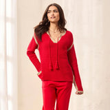 Woman wearing a red outfit with a textured top and pants against a light background