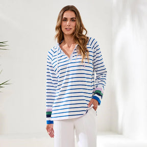 Woman wearing a blue and white striped shirt with colorful cuffs against a white background
