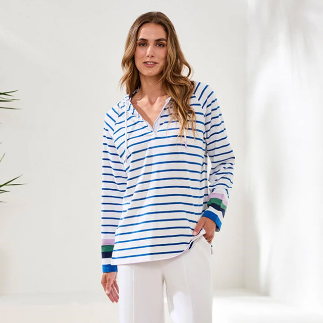 Woman wearing a blue and white striped shirt with colorful cuffs against a white background