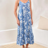 Woman wearing a blue floral dress in a minimal indoor setting
