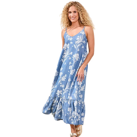 Woman wearing a blue floral dress in a minimal indoor setting