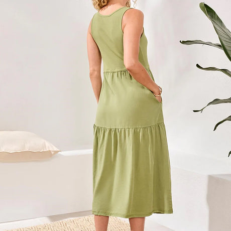 Woman wearing a green dress in a minimal indoor setting
