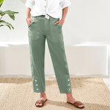 Person wearing green pants with button details indoors