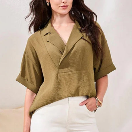 Woman wearing a green blouse with a plain background