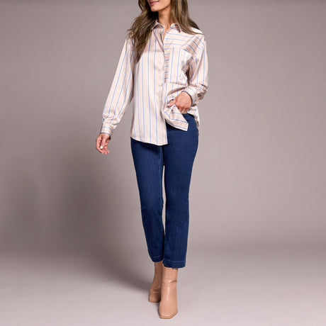 Woman wearing a striped shirt and blue jeans on a plain background