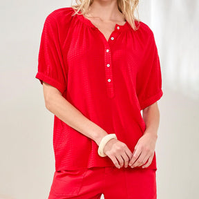 Person wearing a red shirt and pants on a plain background
