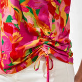 Colorful floral top with a tie detail on a white background