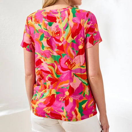 Person wearing a colorful floral t-shirt against a white background