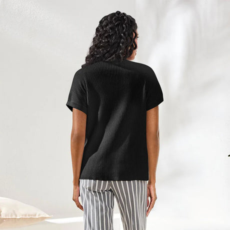 Person wearing a black ribbed t-shirt and striped pants on a white background