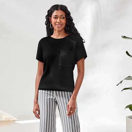 Woman wearing a black top and striped pants against a white background