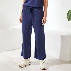 Person wearing navy blue pants with a white background