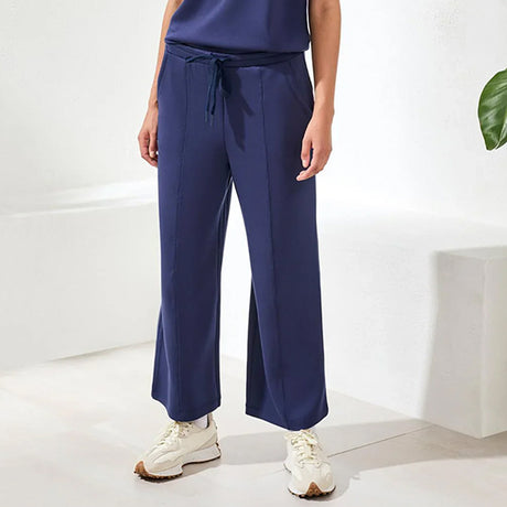 Person wearing navy blue pants with a white background