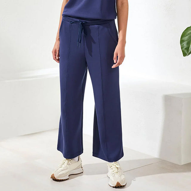 Person wearing navy blue pants with a white background