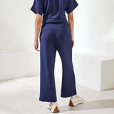 Person wearing a navy outfit with wide-leg pants on a white background