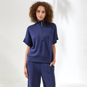 Woman wearing a navy blue outfit with a white background