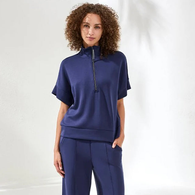 Woman wearing a navy blue outfit with a white background
