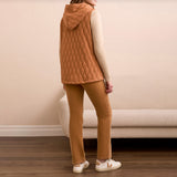 Woman wearing a wheat colored vest over a cream colored sweater with wheat colored pants.