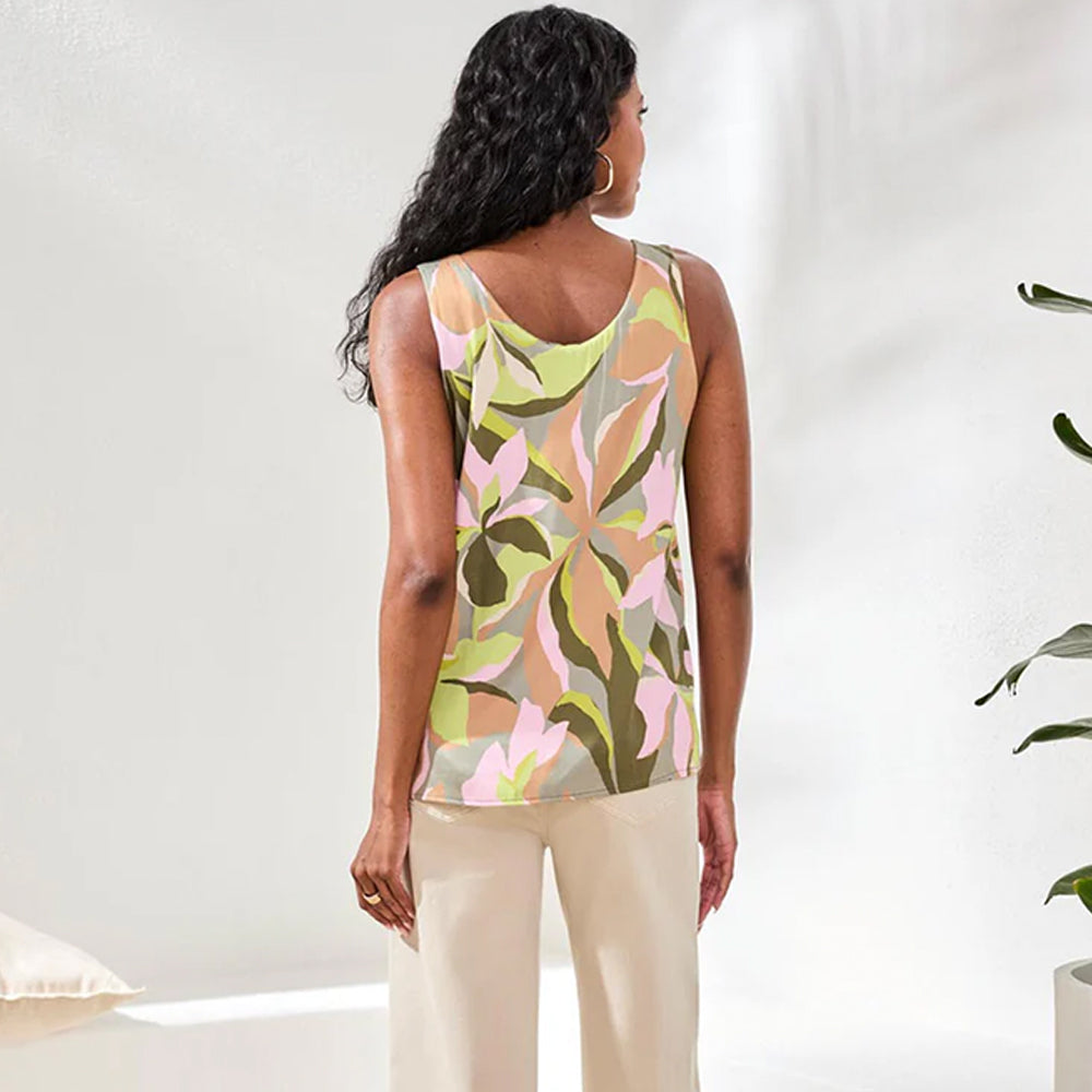 Woman wearing a sleeveless top with a colorful abstract pattern on a white background
