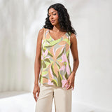 Woman wearing a sleeveless floral top against a white background
