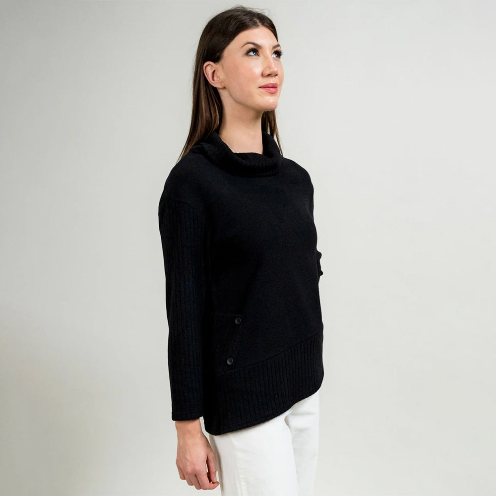 Woman wearing a black sweater against a plain background