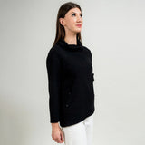 Woman wearing a black sweater against a plain background