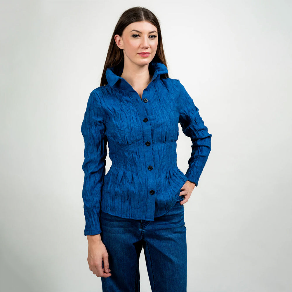 Woman wearing a blue textured shirt and jeans on a white background
