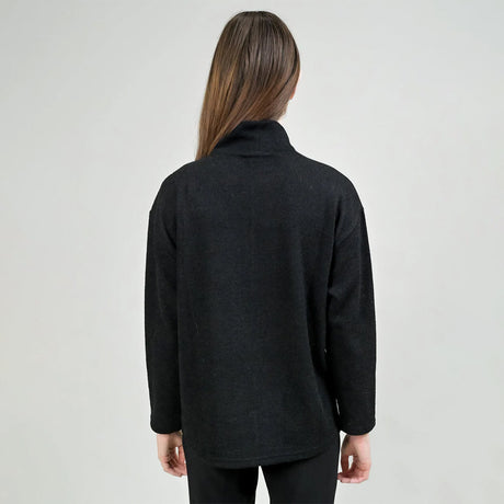 Person wearing a black coat against a plain background