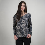 Woman wearing a floral patterned sweater against a plain background