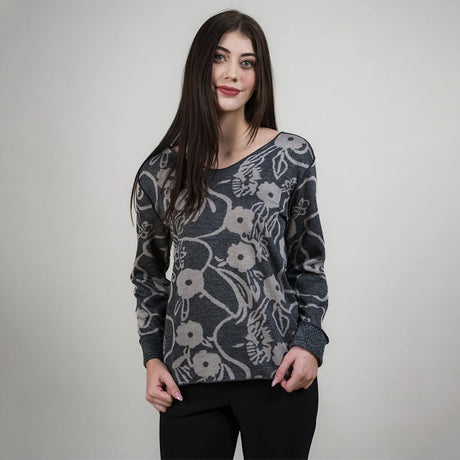 Woman wearing a floral patterned sweater against a plain background