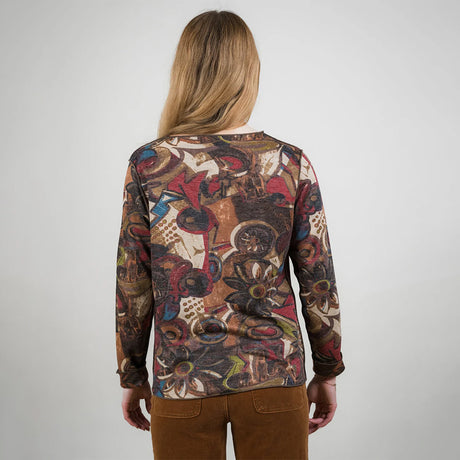 Person wearing a patterned long-sleeve shirt with a plain background