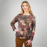 Woman wearing a patterned long-sleeve top against a plain background