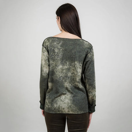 Woman wearing a green patterned top against a white background