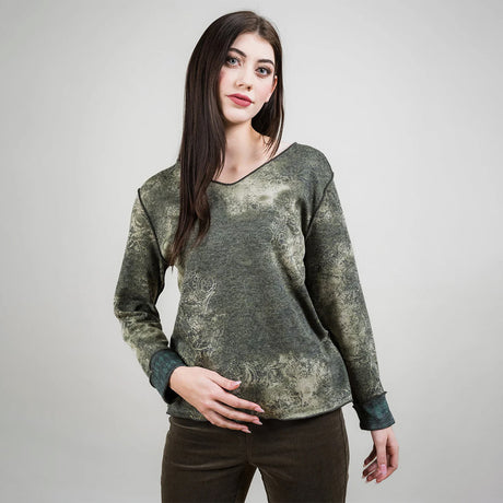 Woman wearing a green patterned sweater against a plain background