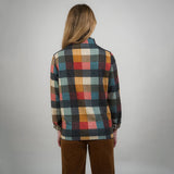 Person wearing a plaid shirt with a neutral background