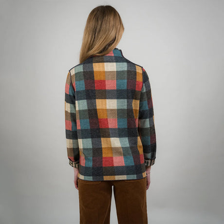 Person wearing a plaid shirt with a neutral background