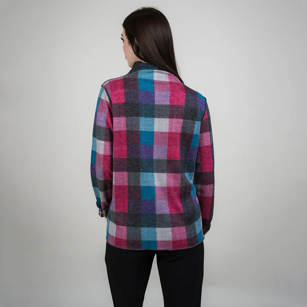 Person wearing a colorful plaid shirt against a plain background