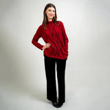 Woman wearing a red sweater and black pants on a white background