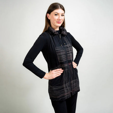 Woman wearing a black and plaid dress against a plain background