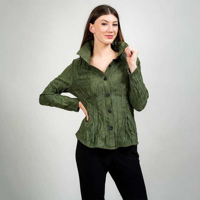 Woman wearing a green jacket against a plain background