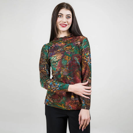 Woman wearing a colorful patterned long-sleeve top against a white background