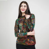 Woman wearing a colorful patterned top against a plain background